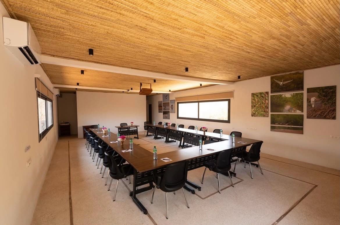 Salle de réunion aménagée, plafond en bois et tables en U