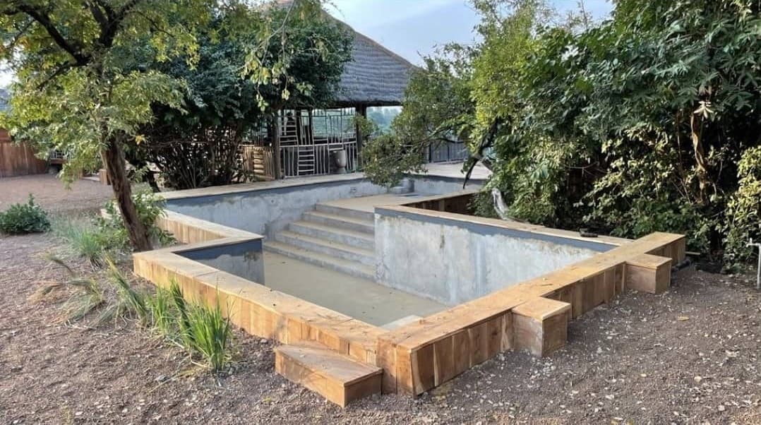 Piscine de Niokolodge en cours de construction : bassin en béton et escalier maçonné